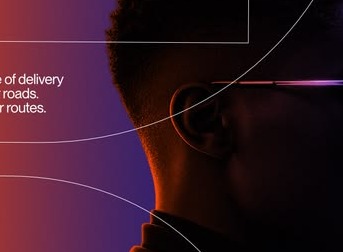 A man in glasses, lit from behind, looking out of frame past ad copy