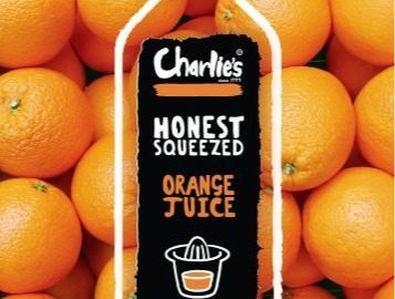 A bottle on a wall of oranges