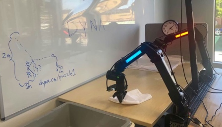 Robot arm writing on a whiteboard in a classroom