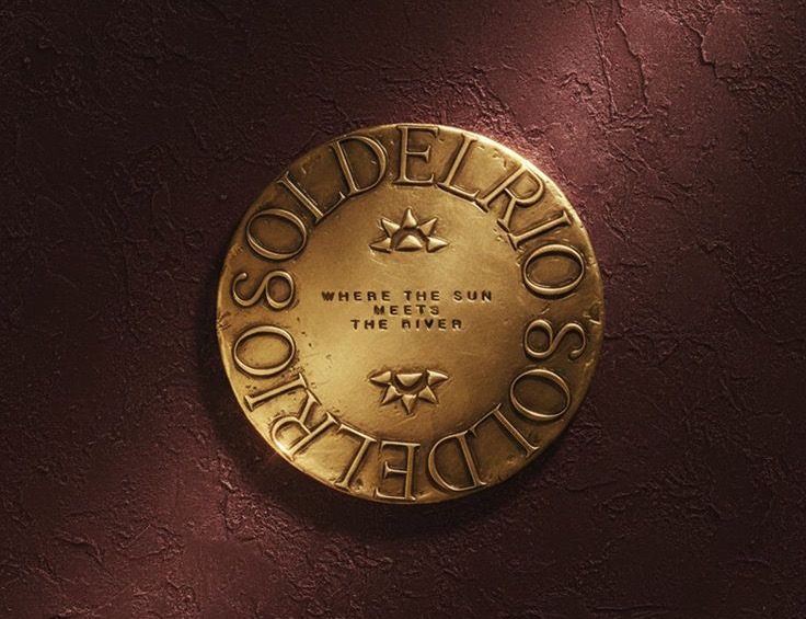 Sol del Rio gold coin mark on a rough plaster wall