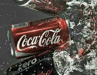 Coke cans tumbling through splashing water on a dark background