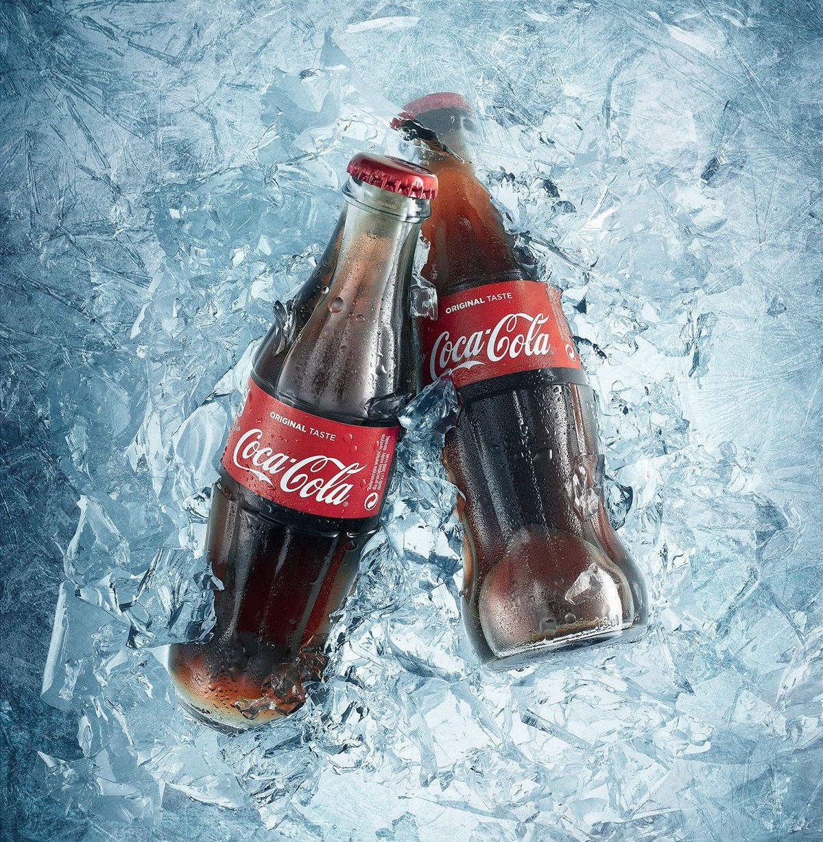 Two glass Coke bottles buried in shattered ice