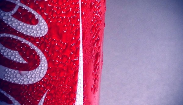 Extreme close-up of a red can surface with condensation drops