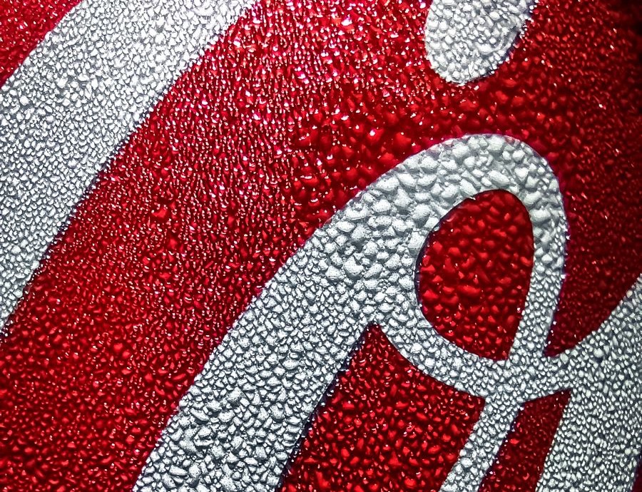 Extreme macro of a Coke can label covered in condensation beads